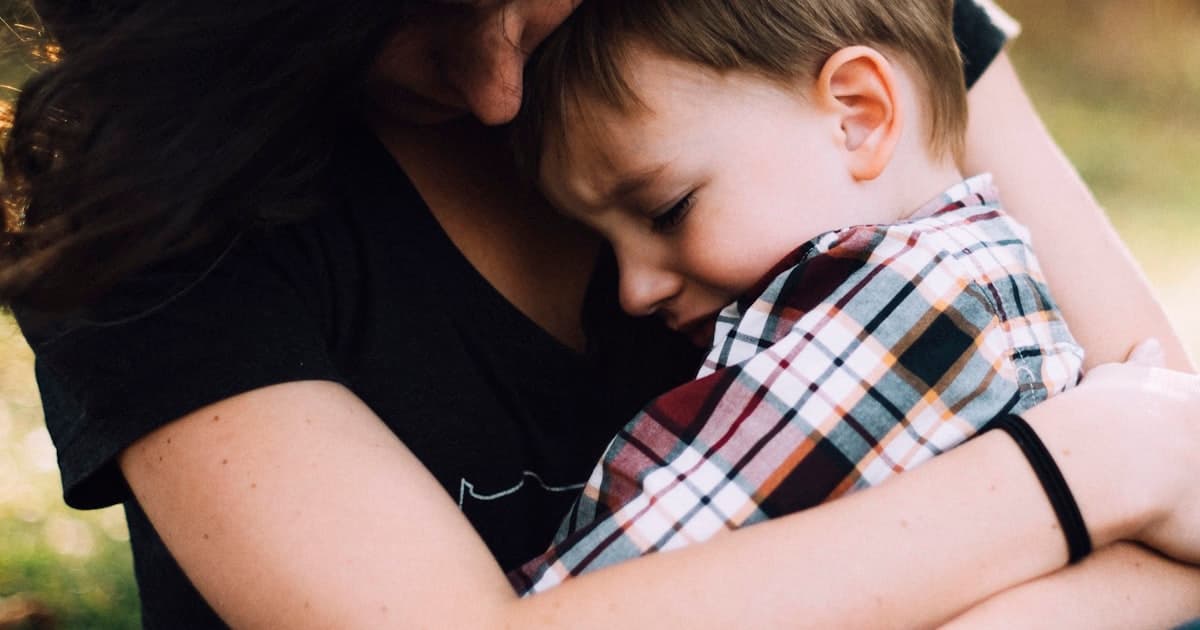 Un parent serre son enfant dans ses bras pour le réconforter